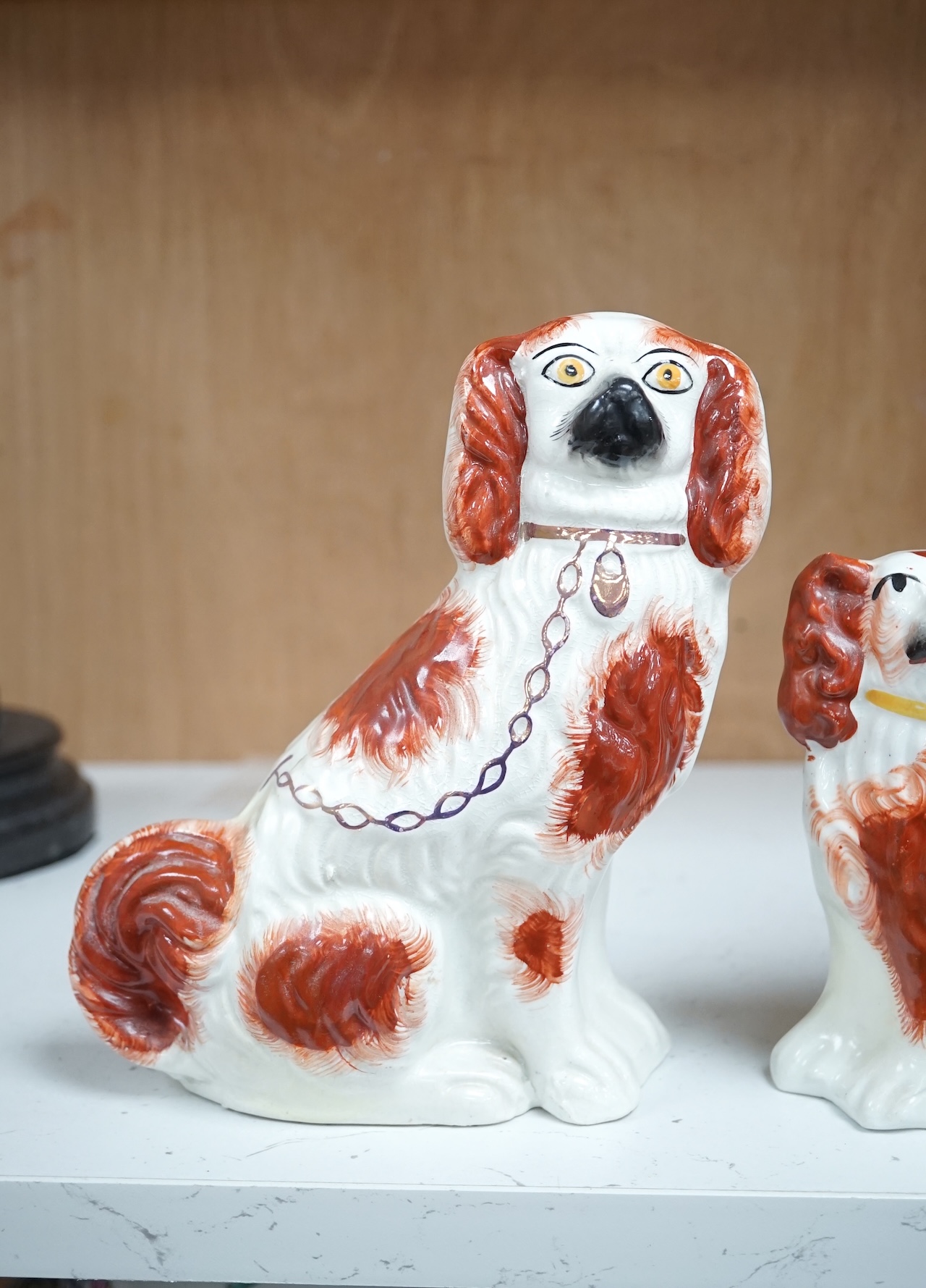 A pair of Staffordshire potter spaniels, and a similar smaller example, taller 18cm. Condition - smaller and one larger heavily restored